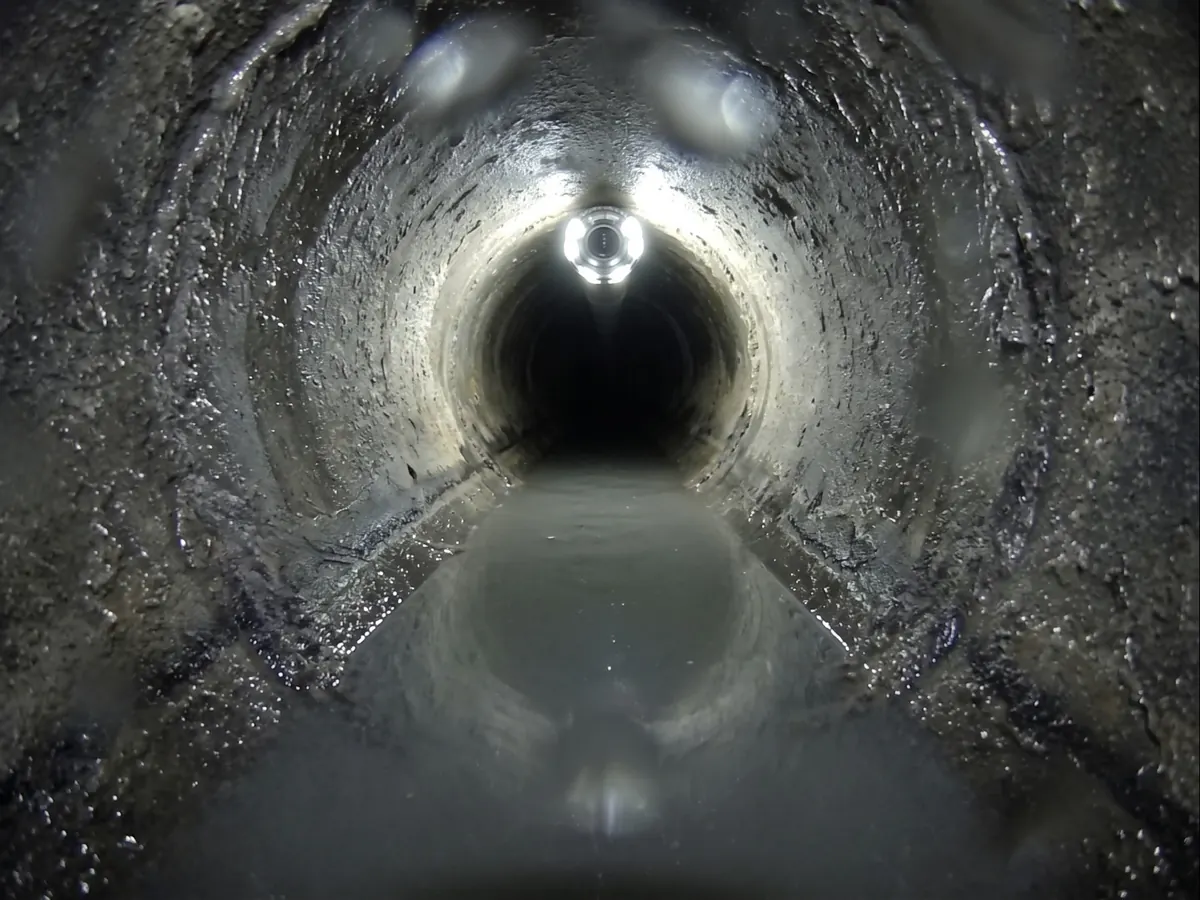 Sewer camera view of standing water pooled in a sagging section of pipe